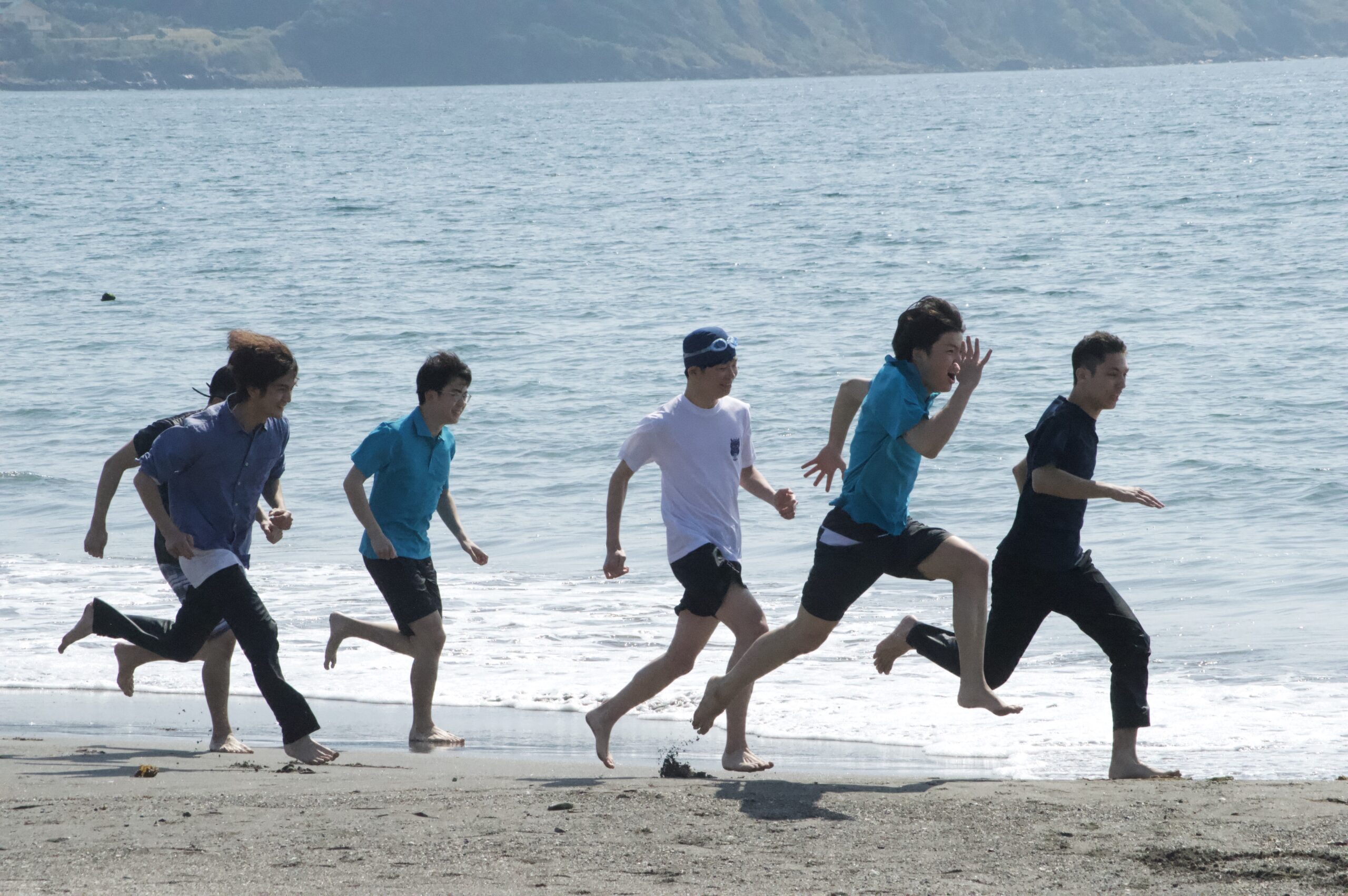 海辺で走る団員たち