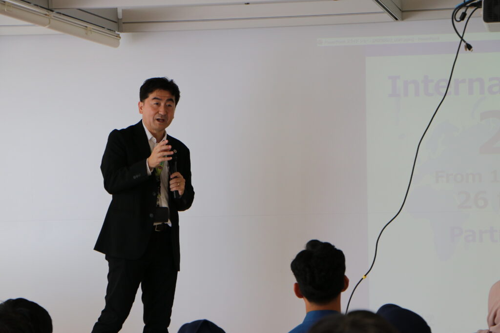 筑波研究学園都市及び筑波大学の説明を行う、野村名可男スチューデントサポートセンター国際交流支援室室長。2025/09/23 澁谷耕大撮影。